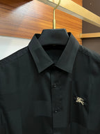 Long-sleeve button-up shirt in dark black with pointed collar and embroidered logo on chest