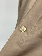 Beige shirt cuff with round button and visible stitched seam