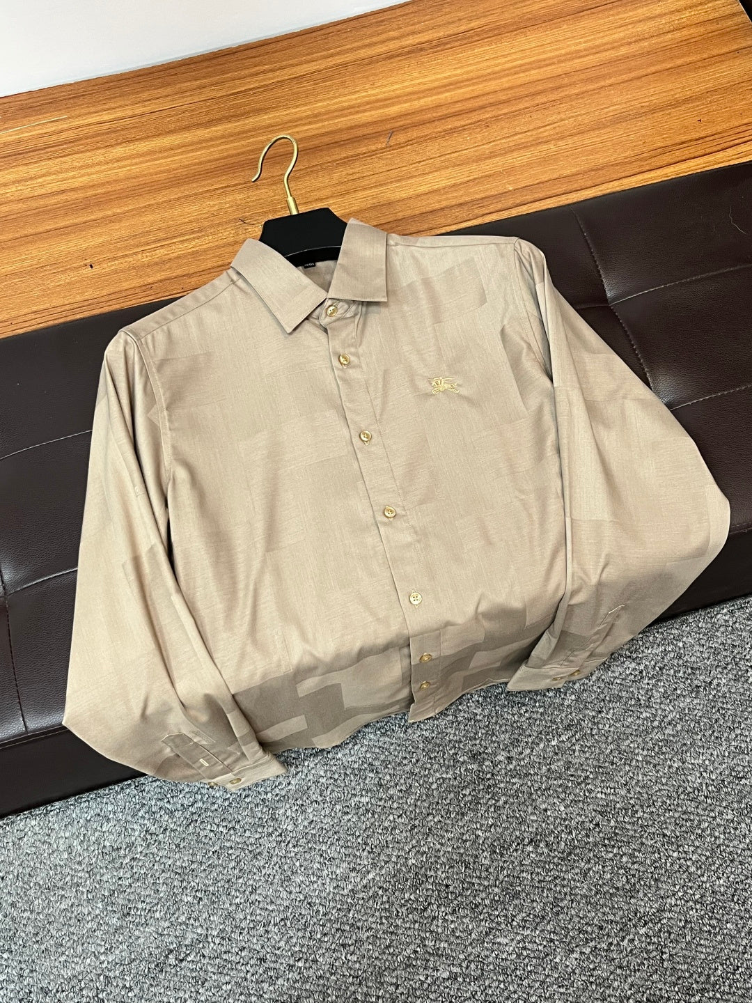 Beige long-sleeve button-up shirt with front buttons and small chest emblem