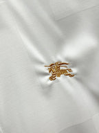 Burberry shirt embroidery: small gold crest on white fabric