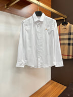 Burberry long-sleeve button-up shirt in white, with gold crest and front buttons