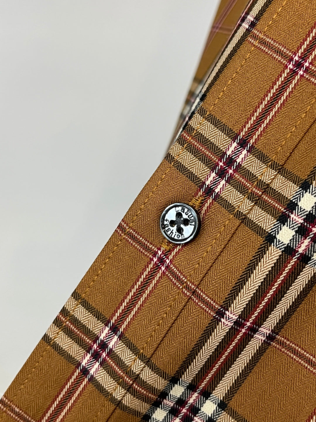Burberry plaid cuff with round logo button, brown tan with white and red accents