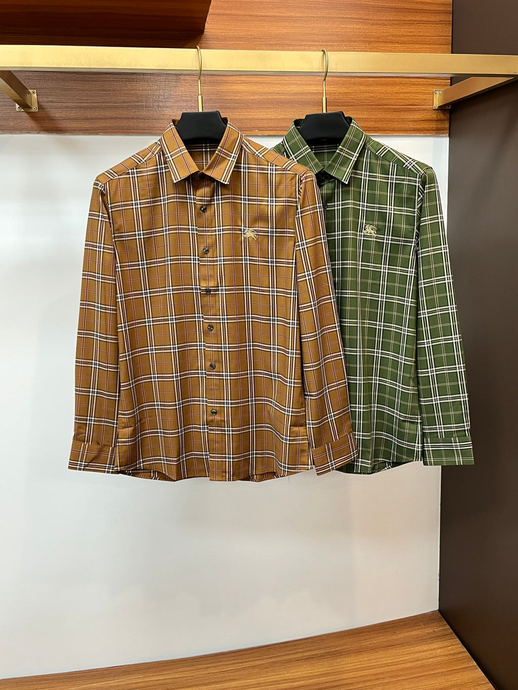 Burberry plaid button-up shirts, one brown tan and one green, each long-sleeve