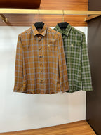 Burberry plaid button-up shirts, one brown tan and one green, each long-sleeve