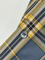 Round button on plaid dress shirt placket in dark blue, white, and yellow