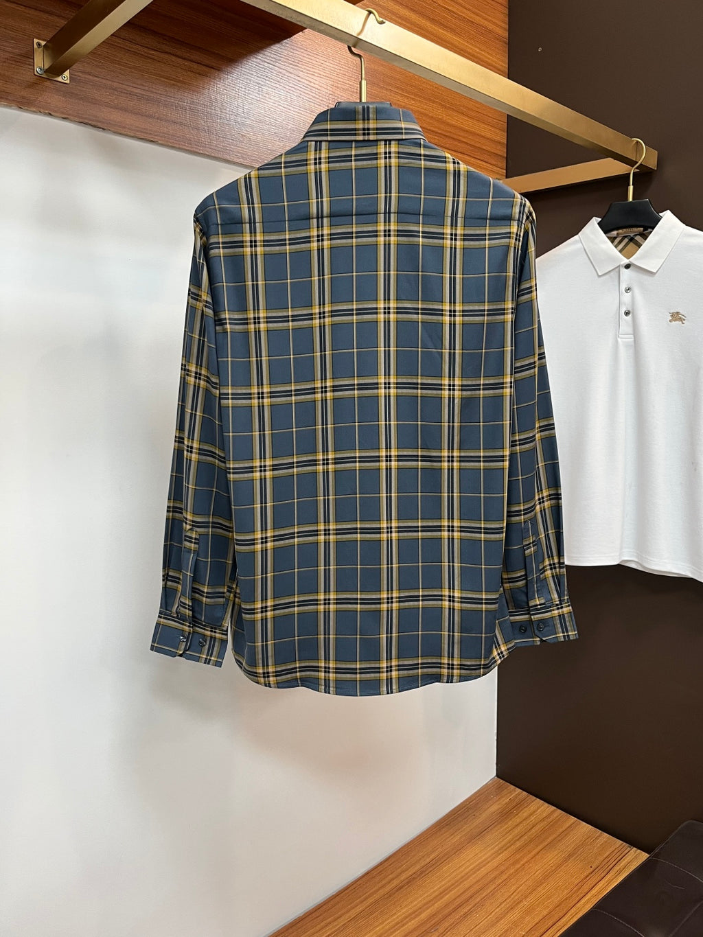 Back view of a blue and yellow plaid dress shirt with long sleeves