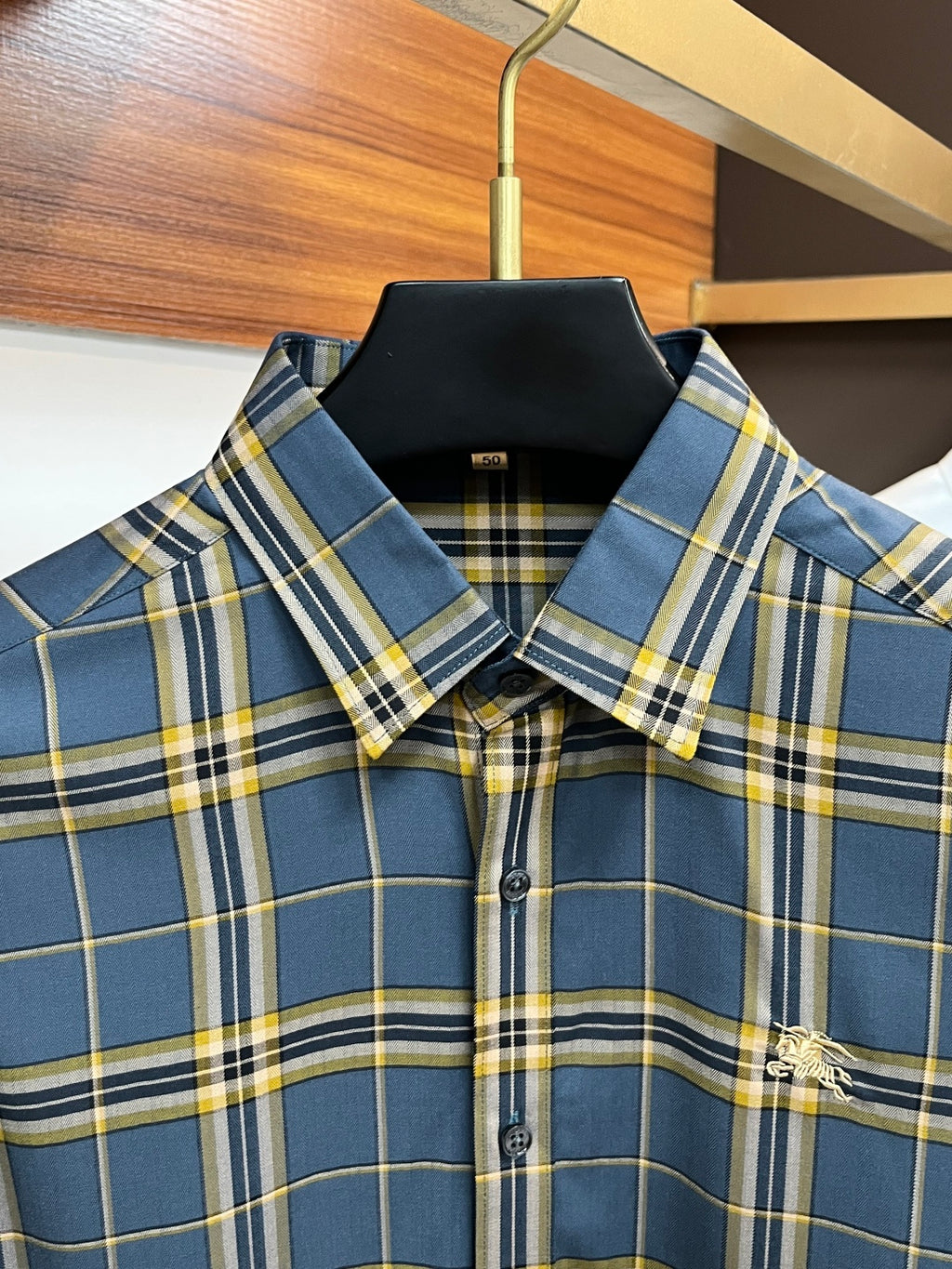 Plaid dress shirt collar and button placket detail in blue, yellow, and white