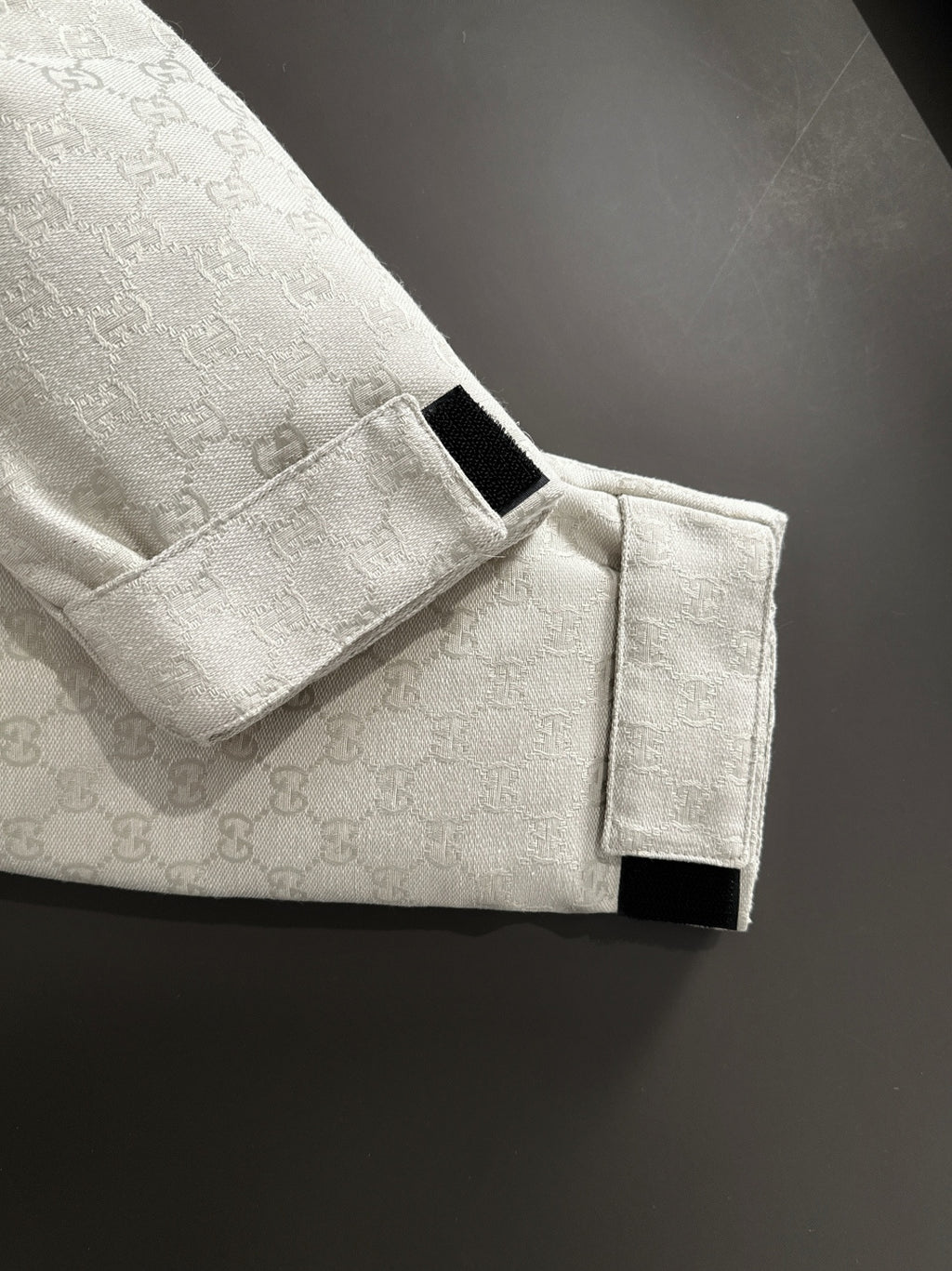 Gucci jacket button strap detail on light-gray monogram sleeve cuff