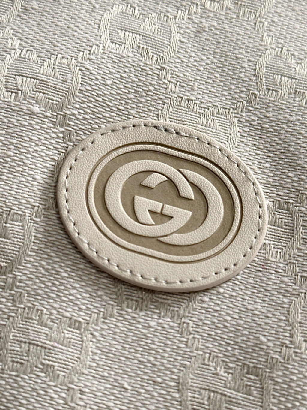 Gucci monogram logo patch on light-gray jacket fabric