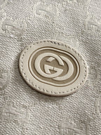 Gucci monogram logo patch on light-gray jacket fabric