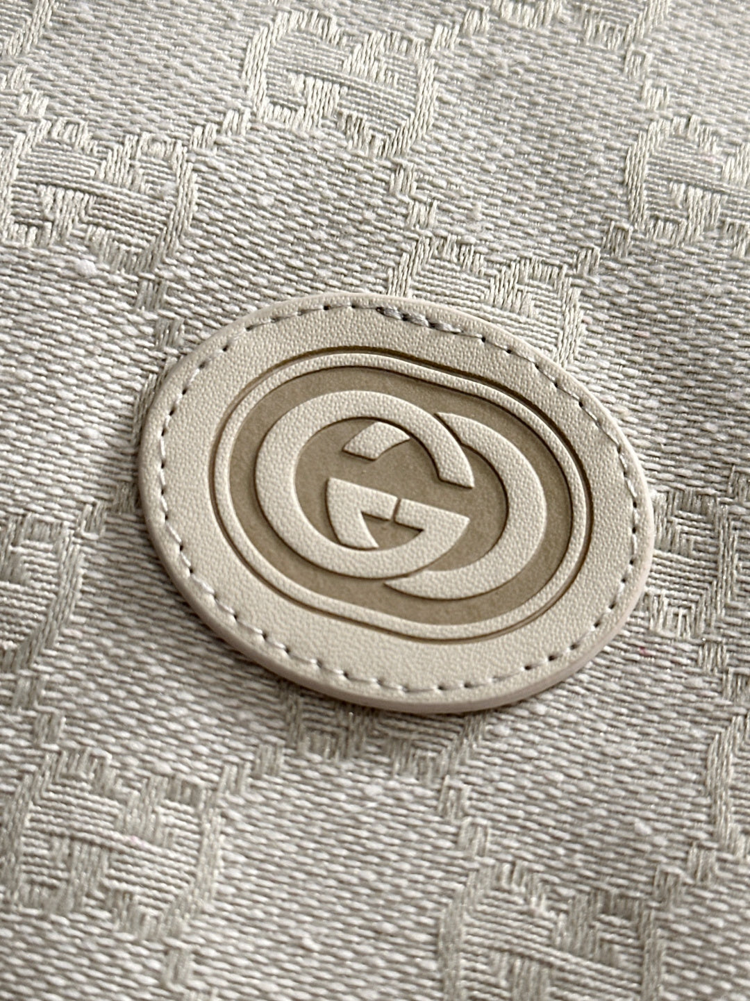 Gucci monogram logo patch on light-gray jacket fabric