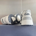 White and black sneakers shown from the heel and outsole, with lace-up upper.