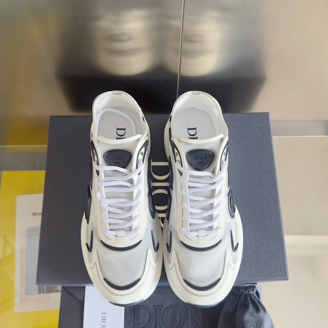 White unisex sneakers with black logo panels, lace-up closure, on a blue box.