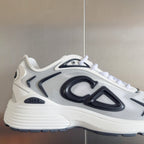 White sneaker with black logo graphic, lace-up front, and thick treaded sole.