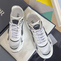 White unisex sneakers with black logo overlays, lace-up front, chunky sole.