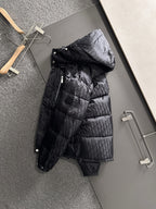 Long black puffer jacket with hood, front zipper, glossy quilted panels, snap placket