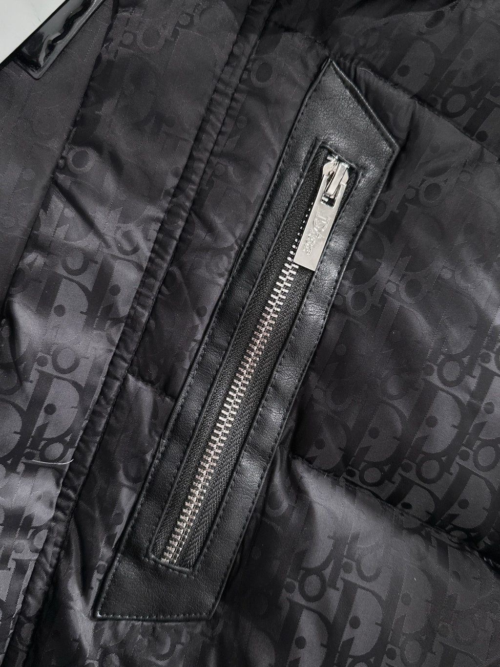 Black puffer jacket front zipper with leather trim, Dior monogram fabric, metal zipper teeth