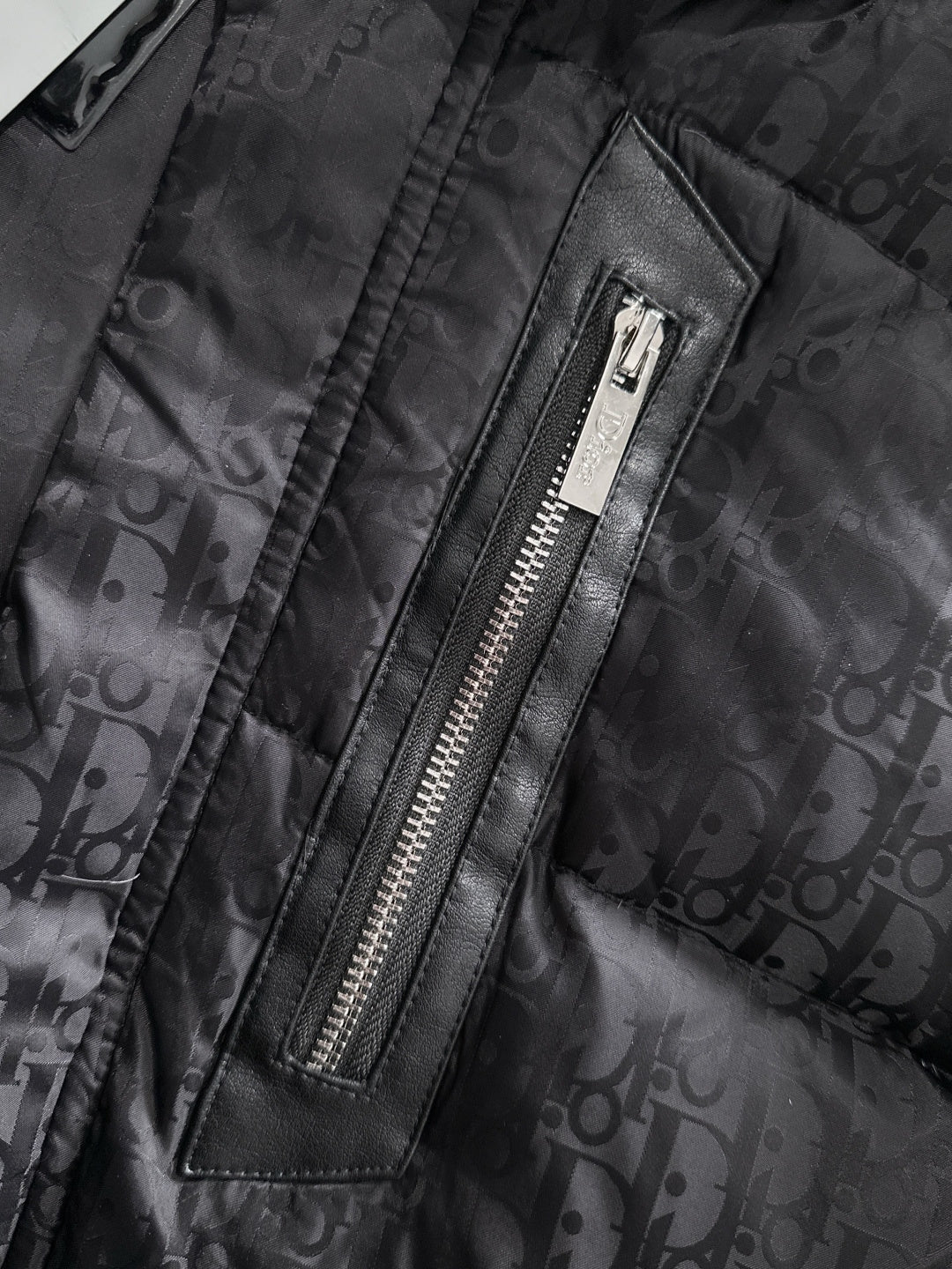 Black puffer jacket front zipper with leather trim, Dior monogram fabric, metal zipper teeth