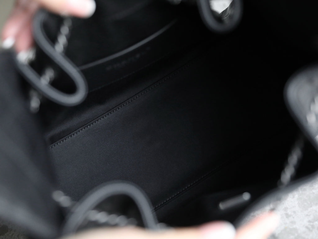 Chanel black leather bag interior with chain strap and stitched trim