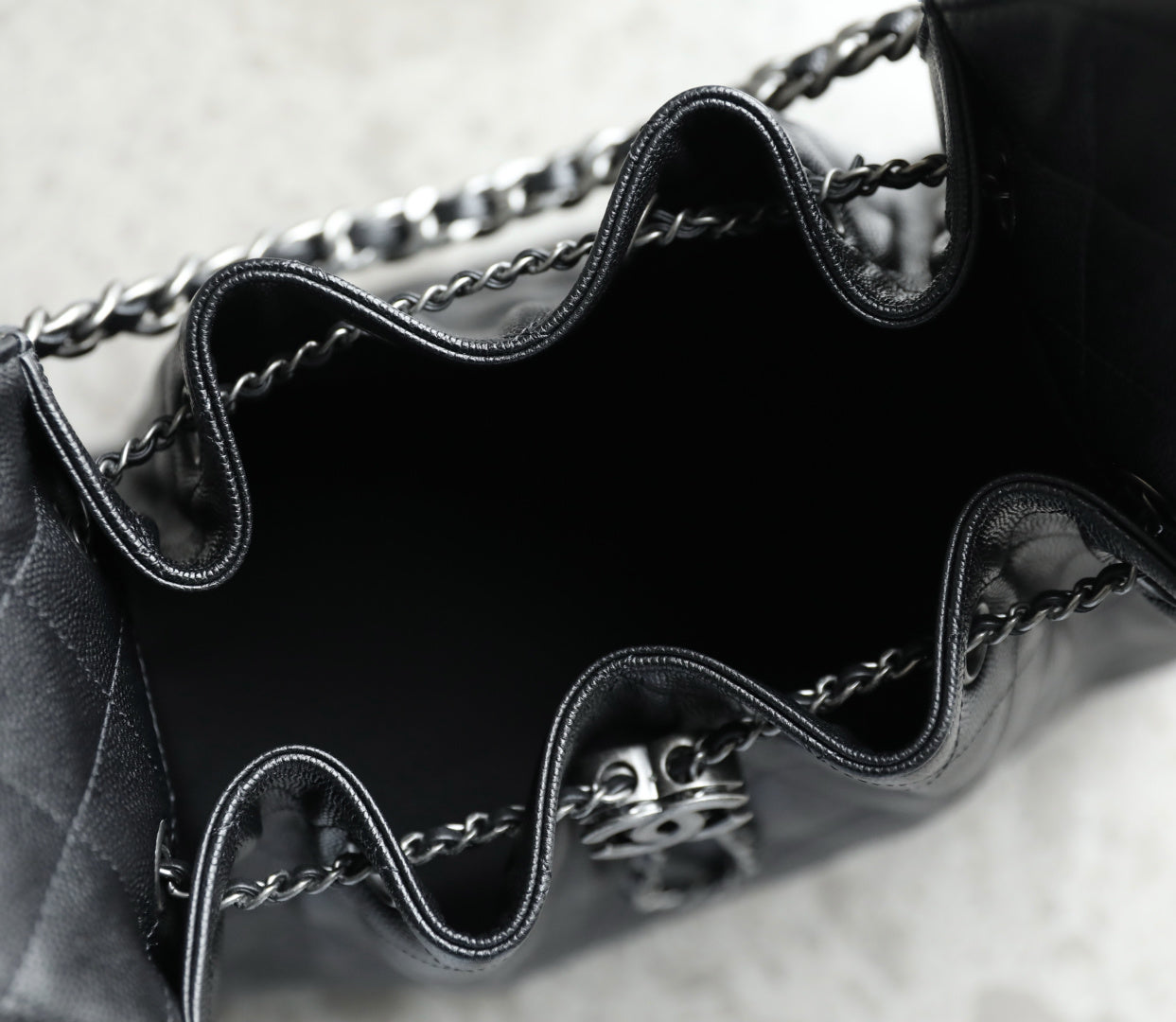 Chanel black leather bag interior with chain strap and metal CC clasp