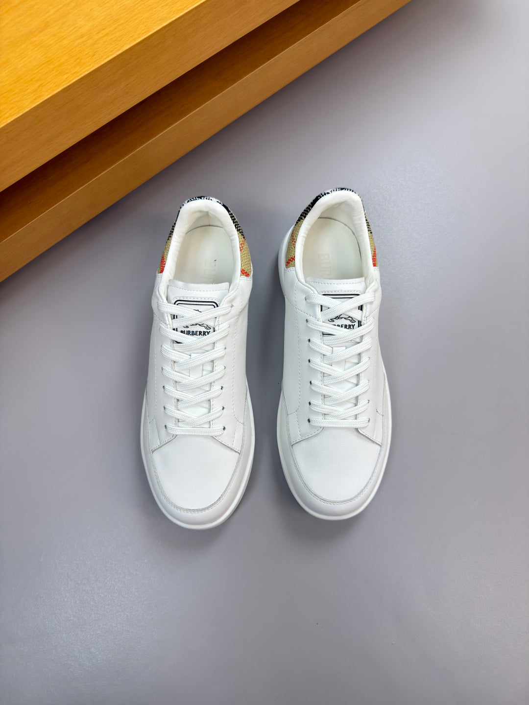 White lace-up sneakers, side panels and stitching visible from above