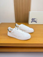 White leather sneakers with lace-up front and low-profile rubber sole