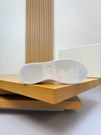 White sneaker outsole with embossed design and traction pattern