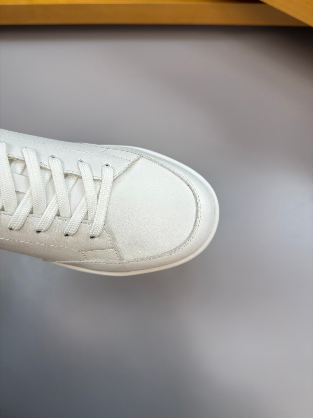 White sneaker toe cap and lace eyelets, smooth leather finish