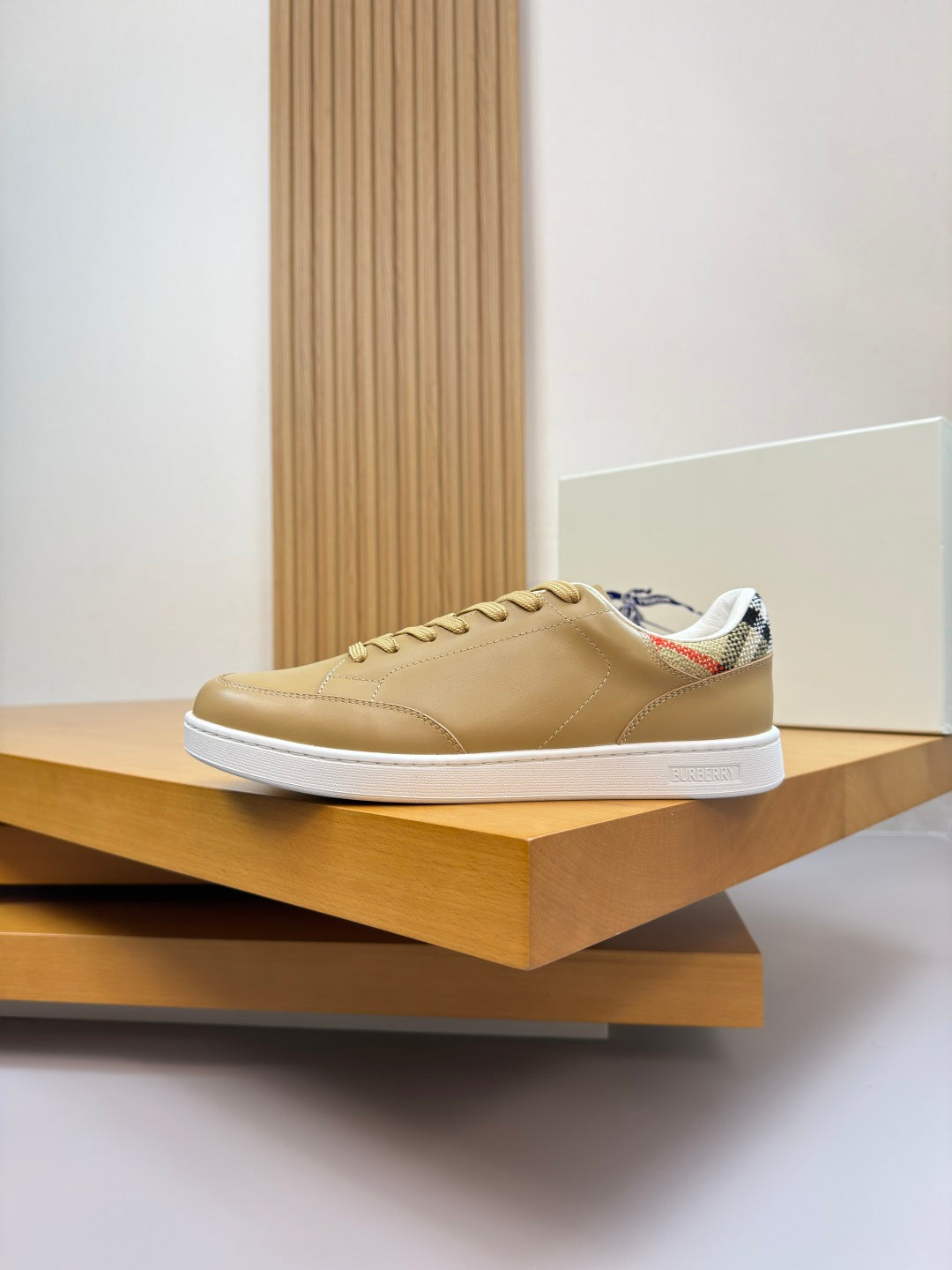 Burberry light tan low-top sneakers on a display shelf with white sole