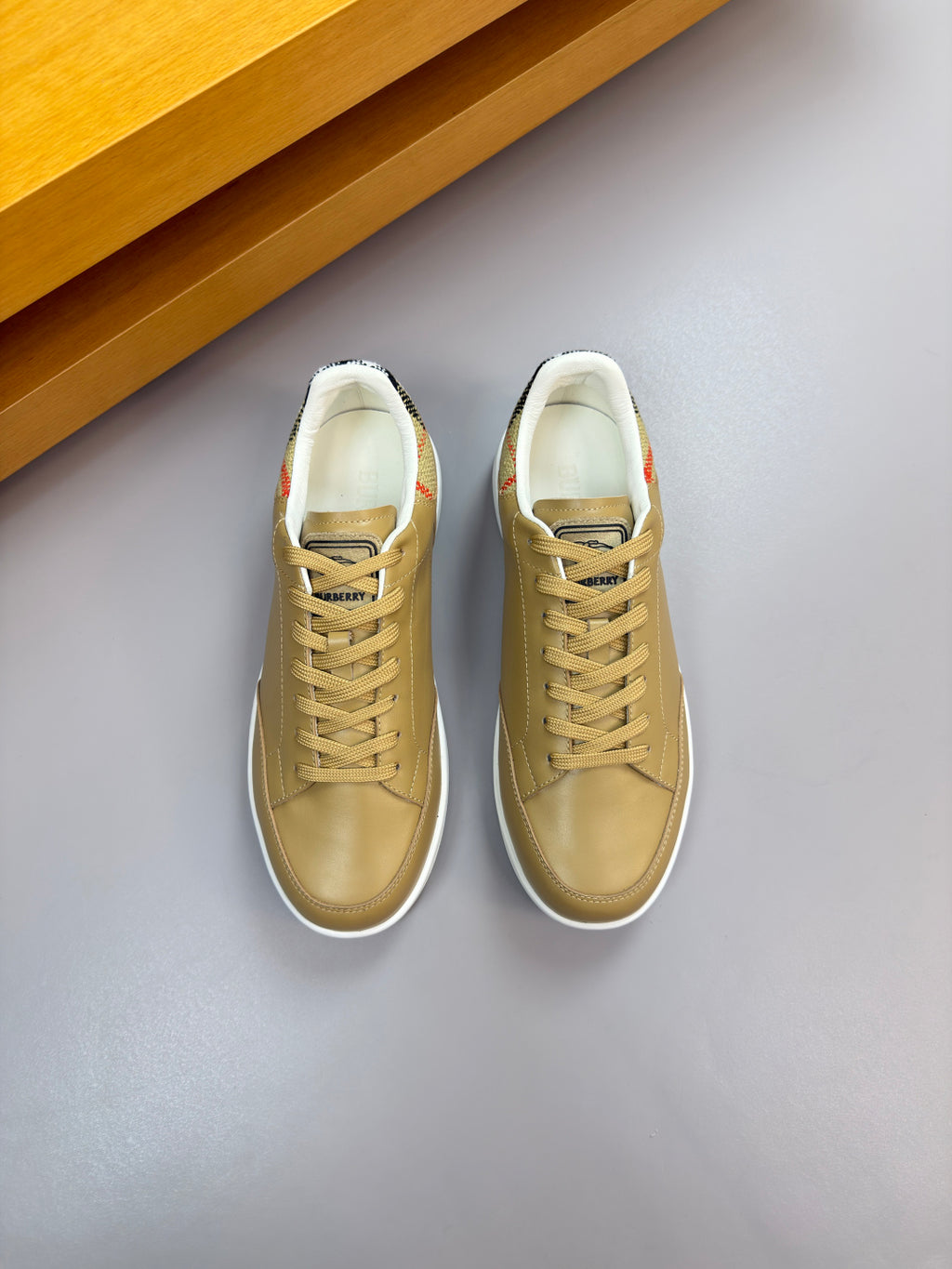 Burberry light tan sneakers, side view with lace-up front and padded collar