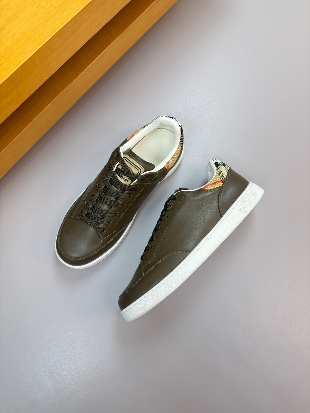 Burberry leather low-top sneakers pair, dark olive with lace-up design and white rubber sole