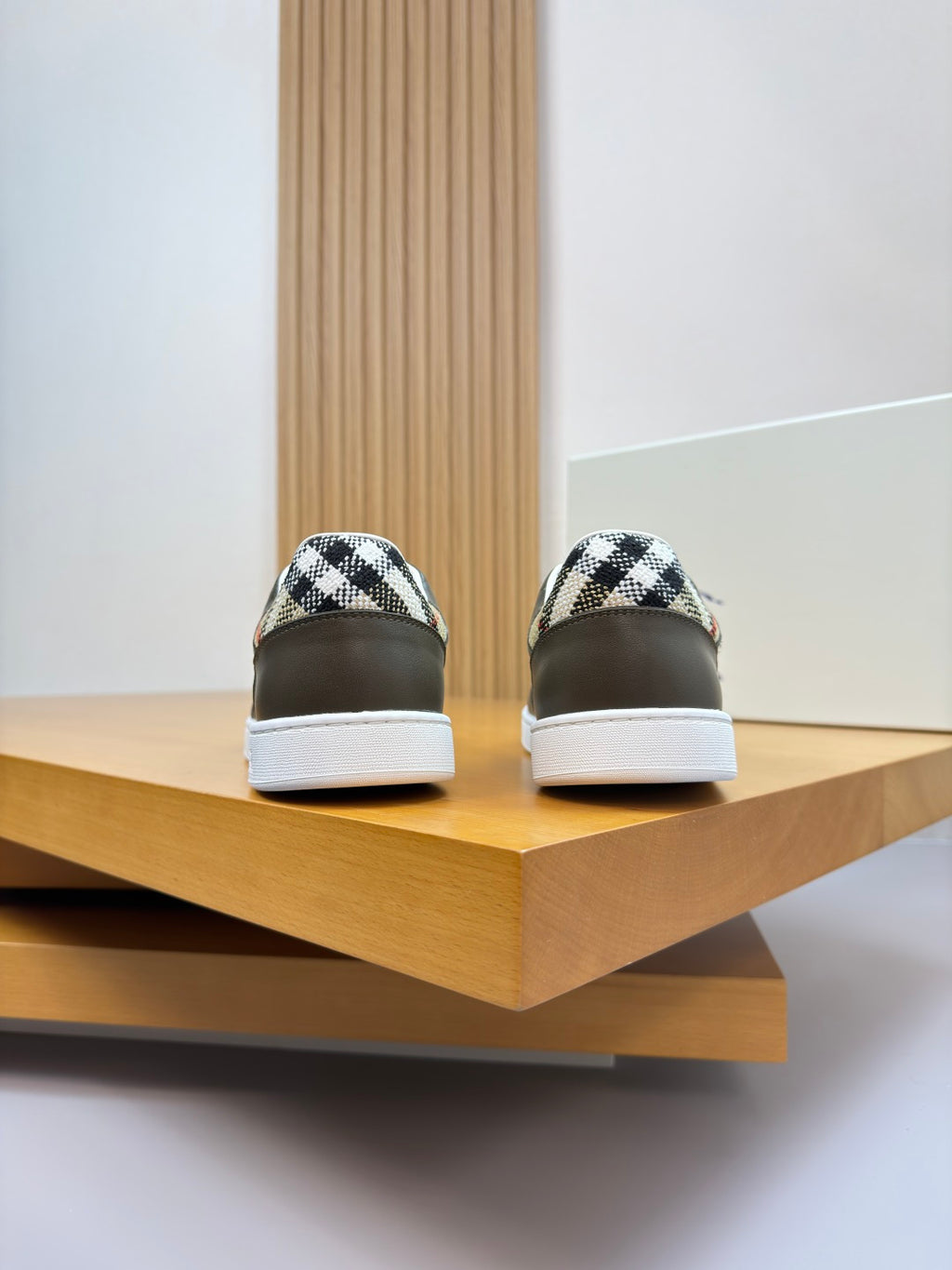 Burberry sneaker heel view pair, dark olive leather with white soles and patterned collar