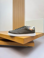 Burberry leather low-top sneakers on display, dark olive with lace-up front and white sole