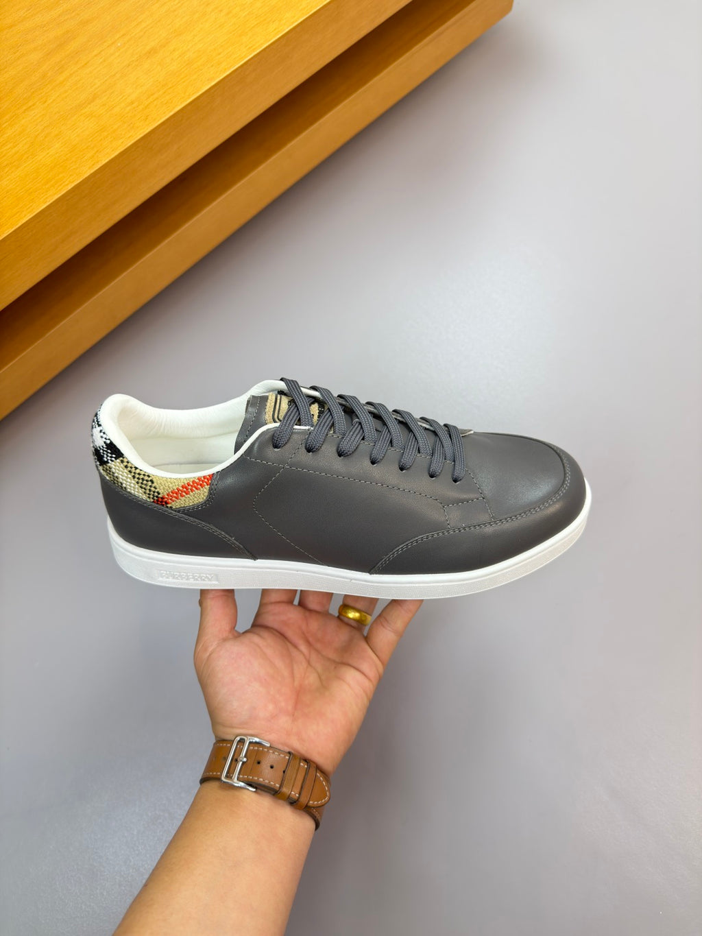 Dark navy lace-up sneaker on hand, white sole and stitching details