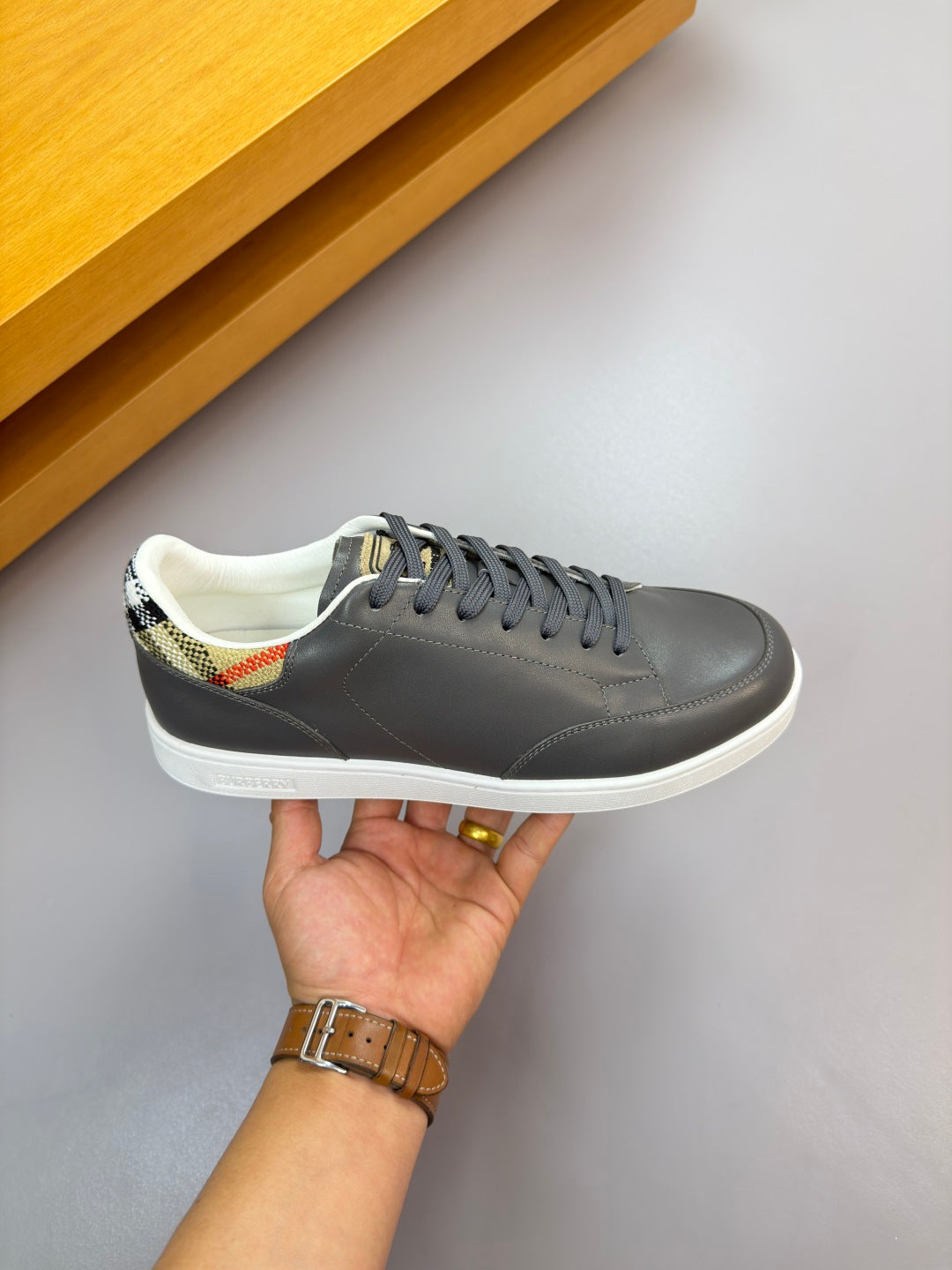 Dark navy lace-up sneaker on hand, white sole and stitching details