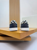 Burberry navy sneakers from heel view with check-pattern collar and white soles