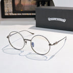 Silver round eyeglasses with blue bridge emblem and decorative metal temple arms.