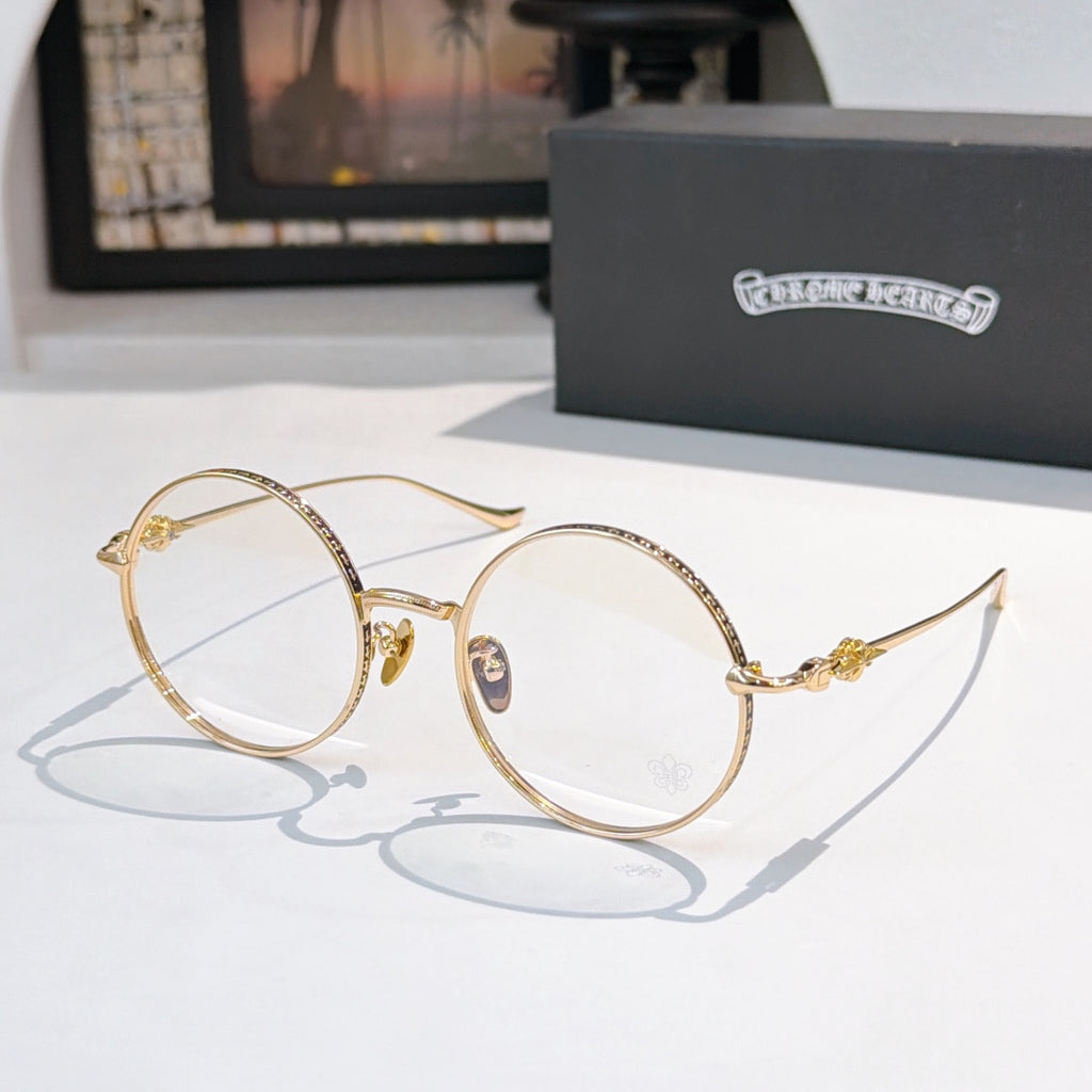 Gold-toned round eyeglasses with thin metal frame and small blue logo on bridge.
