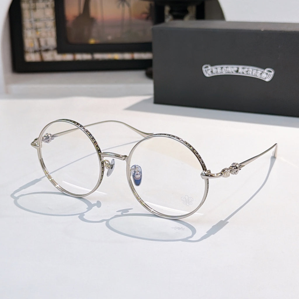 Silver round eyeglasses with blue temple emblem and clear lenses, thin metal frame.