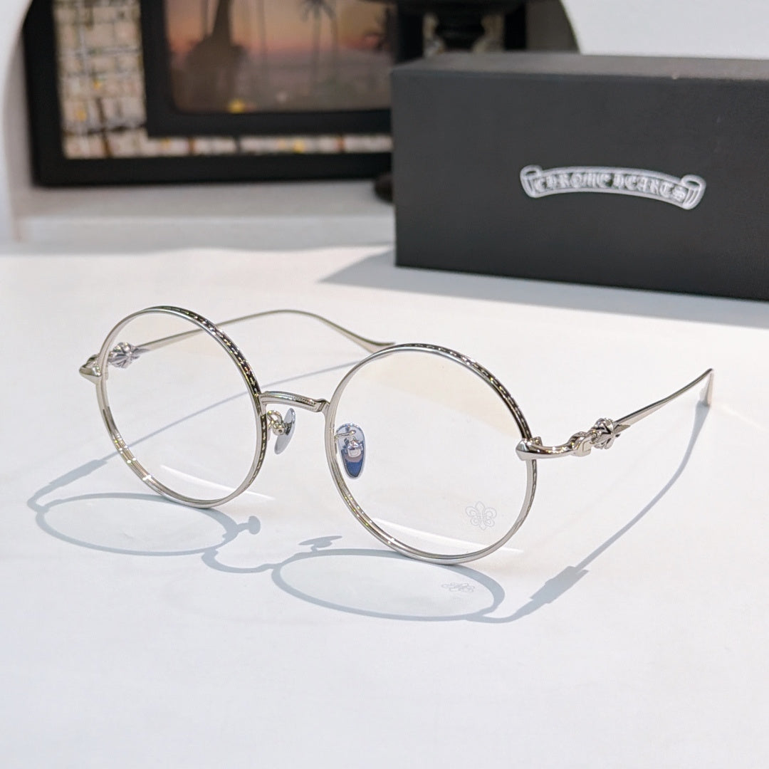Silver round eyeglasses with blue temple emblem and clear lenses, thin metal frame.
