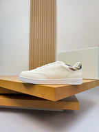 Burberry white lace-up sneakers resting on a shelf