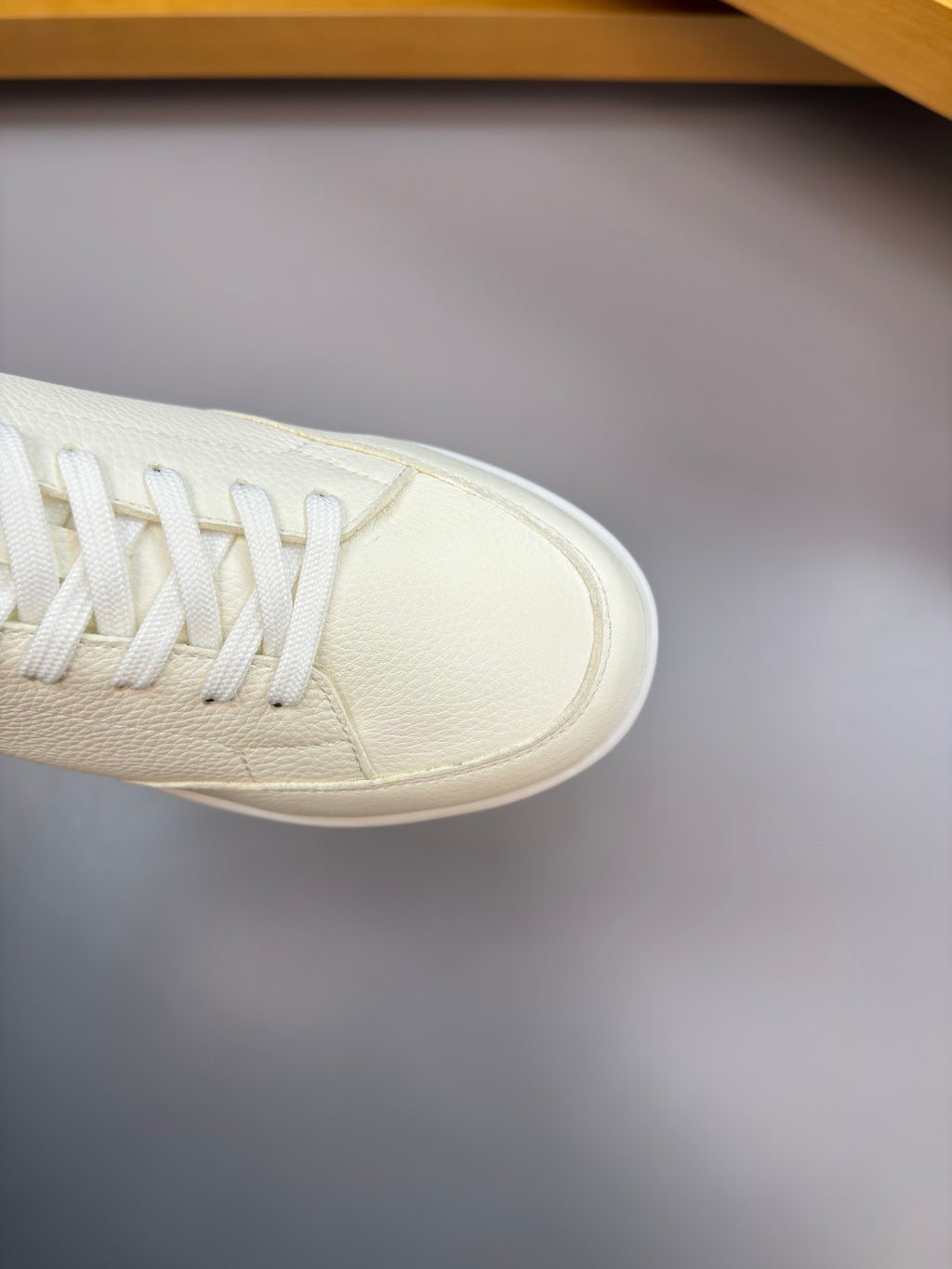 Close-up of white leather sneaker toe and lace panel