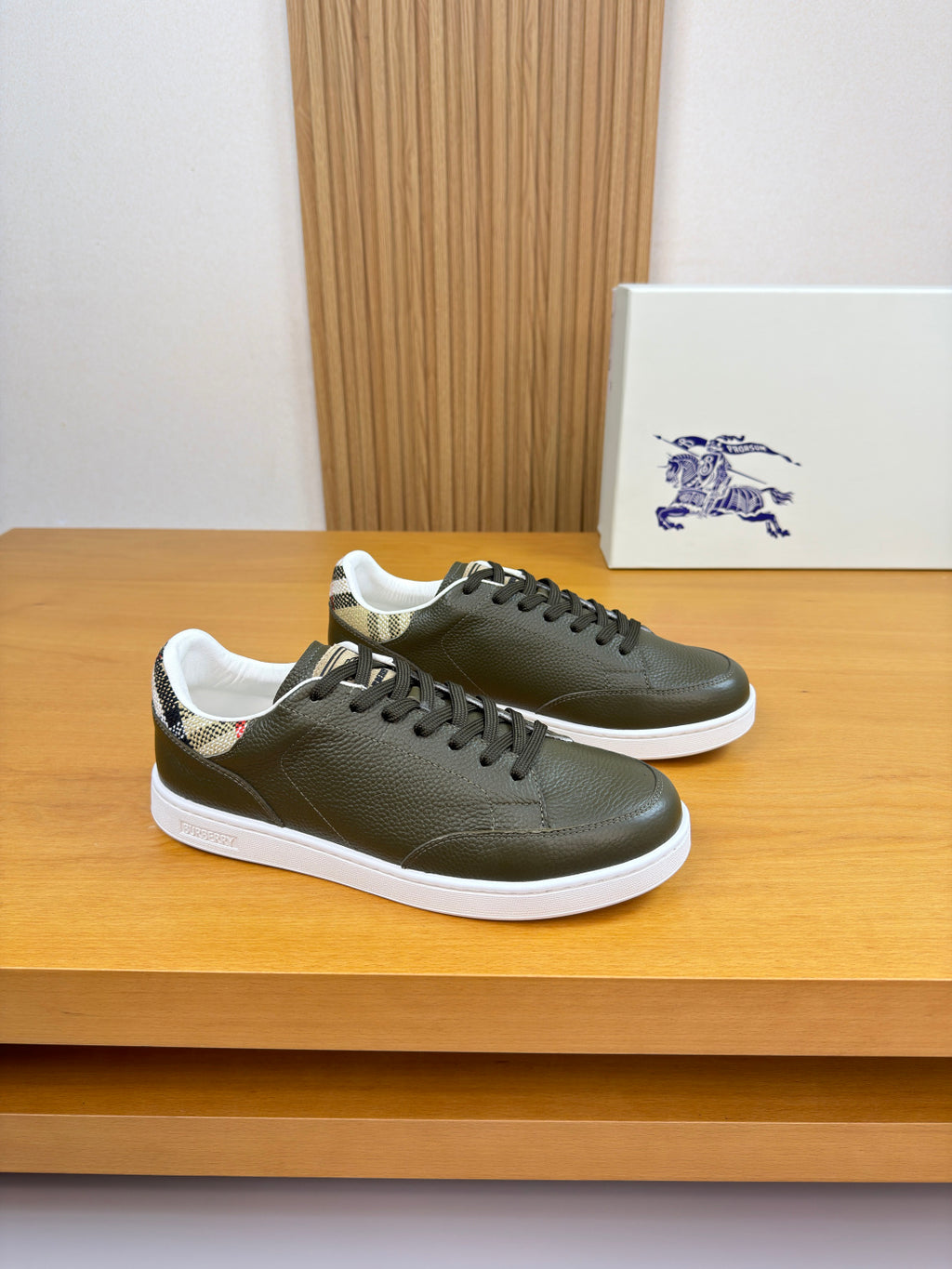 Olive green leather sneakers, lace-up design with black laces and white rubber sole