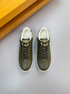 Olive green lace-up sneakers with white-trim collar and lightly textured leather upper