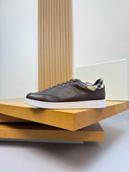 Brown leather low-top sneakers on shelf, with plaid collar and white sole