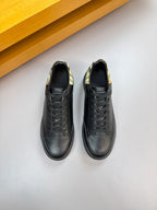 Pair of dark leather low-top sneakers with black laces and patterned lining collar