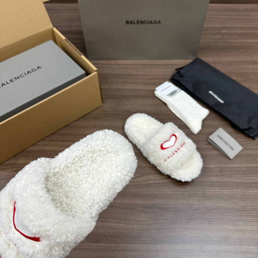 Balenciaga fuzzy white slide sandals with red logo on strap, angled view