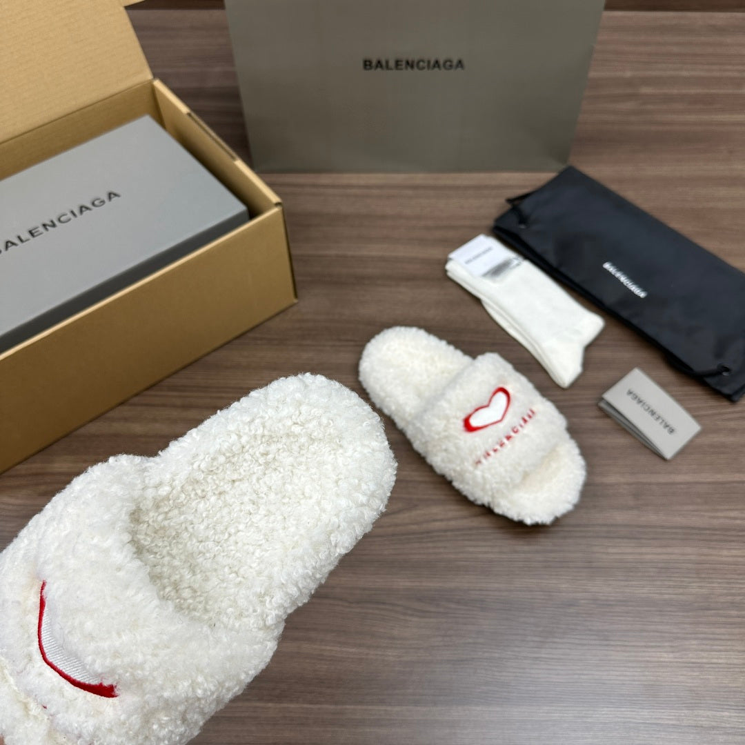 Balenciaga fuzzy white slide sandals with red logo on strap, angled view