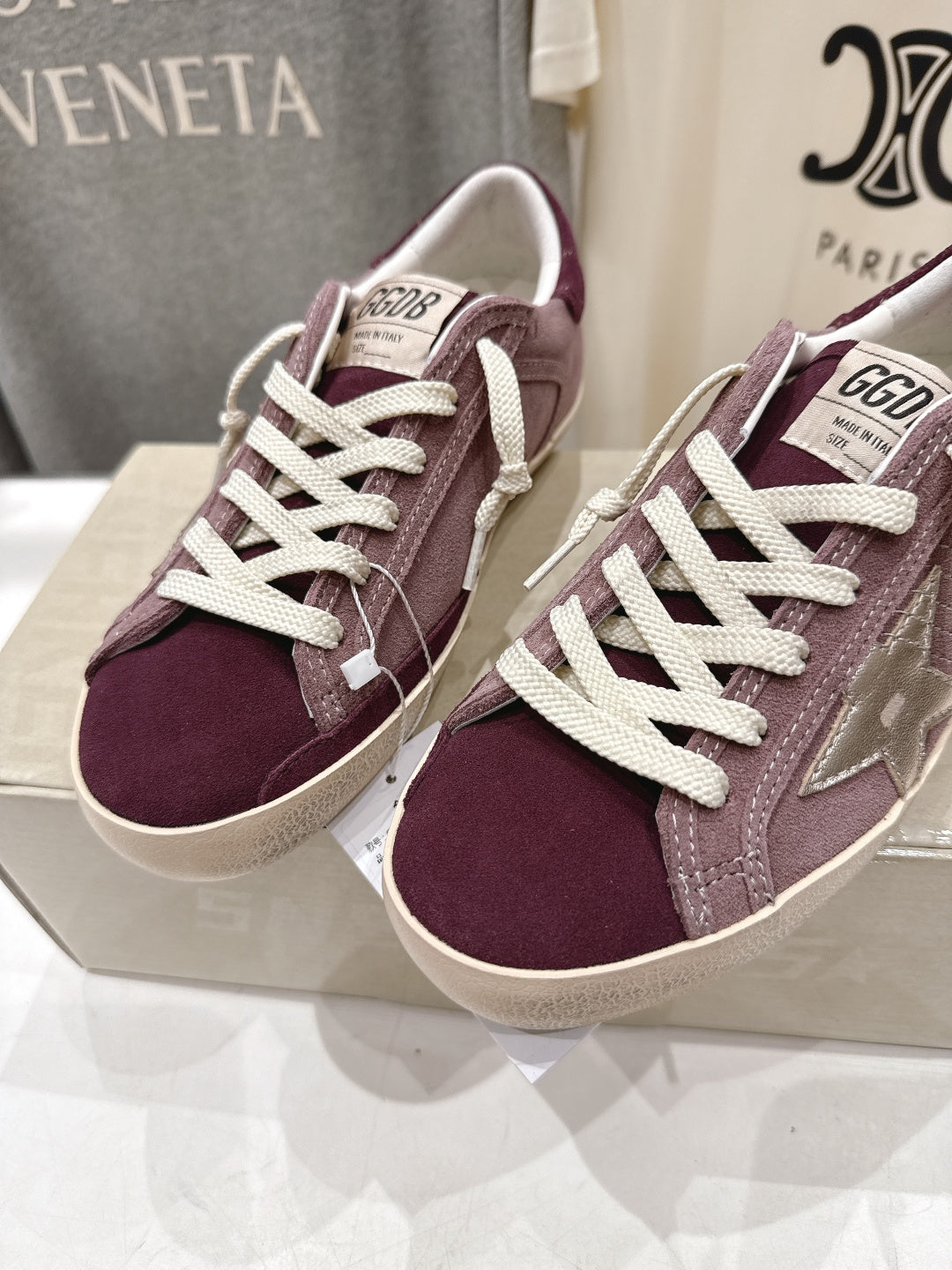Maroon suede sneakers with white laces and padded collar, side-by-side angle.