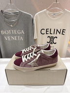 Maroon suede sneakers with white laces and star appliqué, side angle on box.